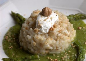 Risotto alle nocciole con crema di asparagi e ricotta di capra servito