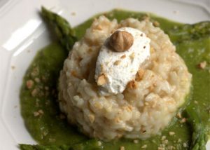 Il risotto agli asparagi presentato con nocciole e ricotta